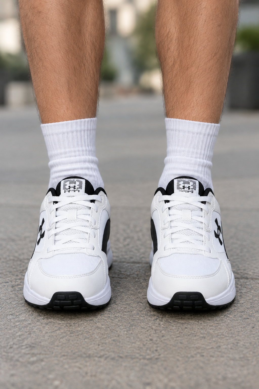 Fehér-fekete Under Armour Charged Edge cipőpár férfilábon, elölnézet